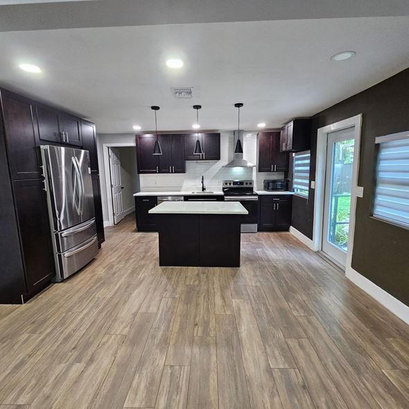 Fort Lauderdale apartment for rent - A modern kitchen with dark wood cabinets and a central island.