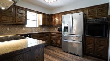 Forney house for rent - A kitchen with wooden cabinets and stainless steel appliances.