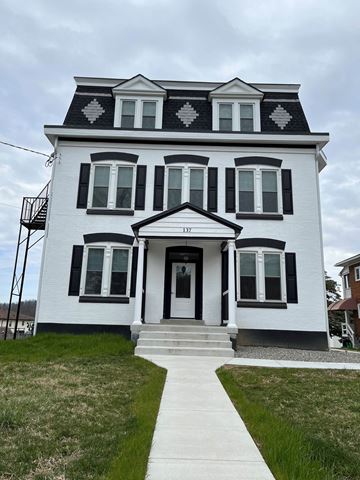 Shillington apartment for rent - A white house with black shutters and a black and white patterned roof.
