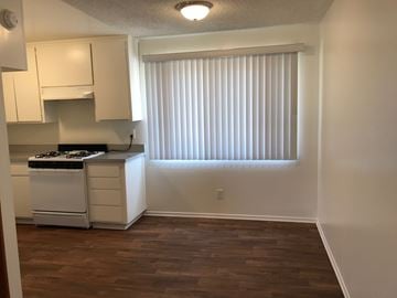 Huntington Beach apartment for rent - A kitchen with white cabinets and a stove top oven.