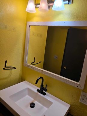Woodland Park house for rent - A bathroom with a yellow wall and a white sink.