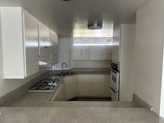 Anaheim apartment for rent - A kitchen with white cabinets and a stove top oven.