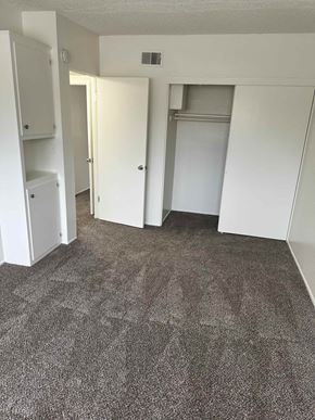 Anaheim apartment for rent - A carpeted room with a doorway leading to another room.