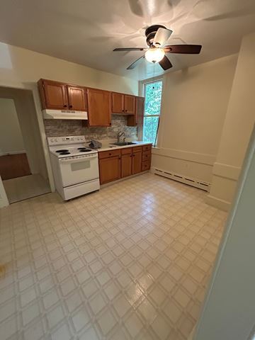 Wernersville apartment for rent - A kitchen with a white tile floor and a white stove top oven.