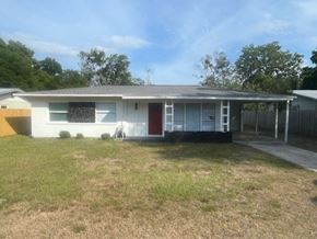 Palatka house for rent - A white house with a red door and a blackboard on the wall.
