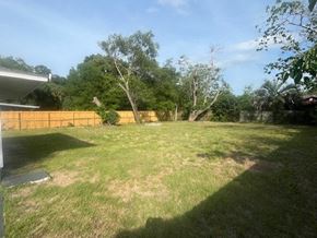 Palatka house for rent - A backyard with a fence and trees.