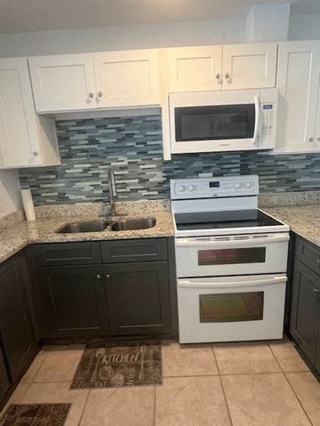 Palatka house for rent - A kitchen with a white stove and black cabinets.