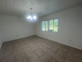 Palatka house for rent - A room with a window and a chandelier.