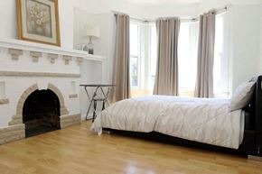 San Francisco house for rent - A bedroom with a fireplace and a bed.