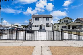 Los Angeles apartment for rent - A white house with a black fence in front of it.