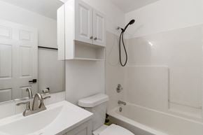 Evans house for rent - A white bathroom with a sink, toilet, and bathtub.