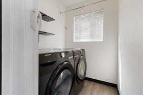 Evans house for rent - A black Samsung washing machine sits in a small laundry room.