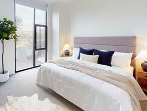 Columbus apartment for rent - A bedroom with a large bed and a potted plant.