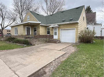 Wausau house for rent - A house with a green roof and a white garage door.