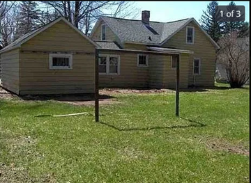 Wisconsin Rapids house for rent - A small house with a yellowish exterior is shown in the image.