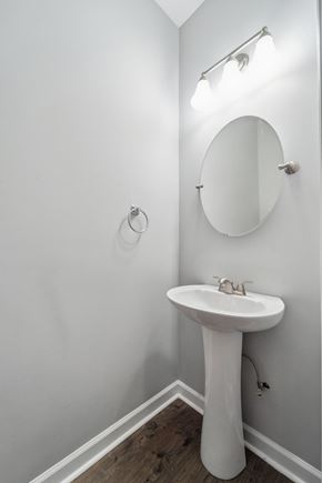 Jacksonville house for rent - A white pedestal sink with a round mirror above it.