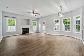 Jacksonville house for rent - A spacious room with a fireplace and a ceiling fan.