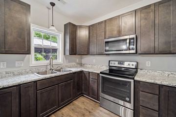Jacksonville house for rent - A kitchen with dark wood cabinets and stainless steel appliances.