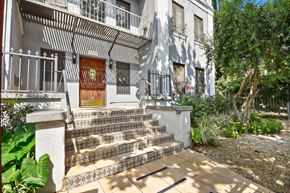 Los Angeles apartment for rent - A white building with a brown door and a metal railing.