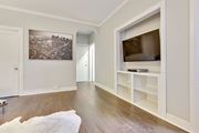 Los Angeles apartment for rent - A living room with a white rug, a black and white photo on the wall, a television, and a book on the shelf.
