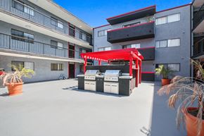 Los Angeles apartment for rent - A red awning is over a grill and sink outside a building.