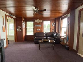 Brazoria house for rent - A living room with a brown ceiling and a black leather couch.