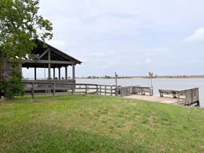 Brazoria house for rent - A gazebo sits on a grassy area next to a body of water.