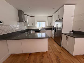 Coronado apartment for rent - A kitchen with white cabinets and a black countertop.