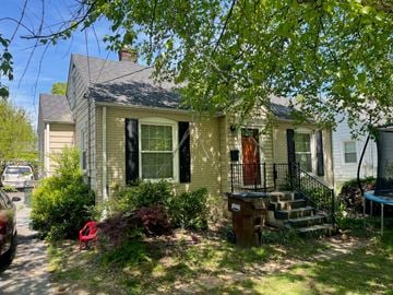 Louisville house for rent - A house with a red door and a brown trash can.