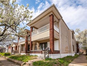 Louisville apartment for rent - A two-story house with a balcony and a brick chimney.