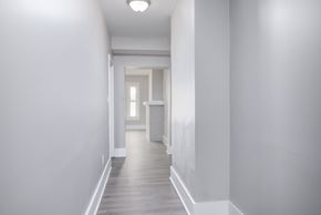 Louisville apartment for rent - A long white hallway with a door at the end.