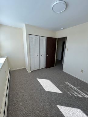 Reading apartment for rent - A room with a carpeted floor and a white ceiling with a light fixture.