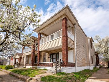 Louisville apartment for rent - A two-story house with a balcony and a brick chimney.