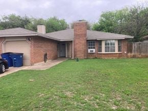 Austin house for rent - A house with a brown brick exterior and a grey roof.