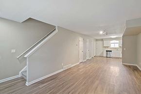 Longmont apartment for rent - A spacious room with wooden floors and a staircase.