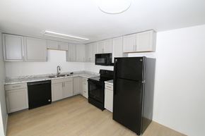 Lakewood apartment for rent - A kitchen with black appliances and white cabinets.