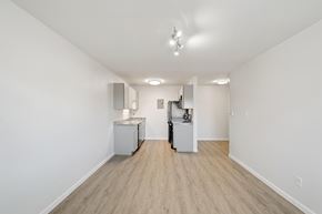 Longmont apartment for rent - A white room with a kitchenette and a vacuum cleaner.
