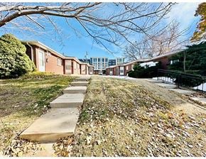 Denver apartment for rent - A row of houses with a sidewalk and fallen leaves.