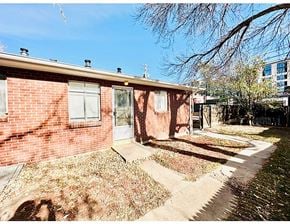 Denver apartment for rent - A red brick house with a white door and windows.