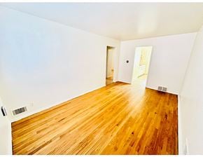 Denver apartment for rent - A room with wooden floors and white walls.