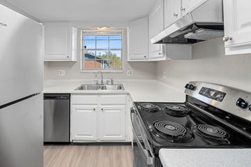 Lakewood apartment for rent - A kitchen with white cabinets and a black stove top oven.
