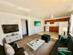 Aurora apartment for rent - A living room with a black couch, a white coffee table, and a flat screen TV.