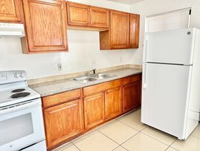 Aurora apartment for rent - A kitchen with wooden cabinets and a white refrigerator.