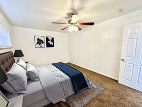 Aurora apartment for rent - A bedroom with a bed, pillows, a ceiling fan, and two pictures on the wall.