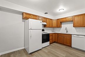 Denver apartment for rent - A kitchen with wooden cabinets and white appliances.