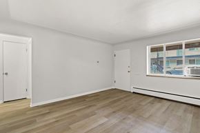Denver apartment for rent - A room with white walls and wooden flooring with a window on the right side.