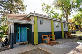 Denver apartment for rent - A small house with a blue door and a yellow stripe on the side.