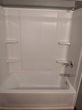 Salineville apartment for rent - A white bathtub with a silver faucet and handles.