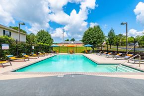 Cleveland apartment for rent - A large outdoor swimming pool surrounded by sun loungers and trees.