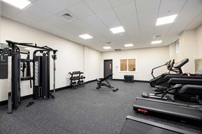 Hudson apartment for rent - A gym with a variety of equipment including treadmills, weights, and exercise machines.